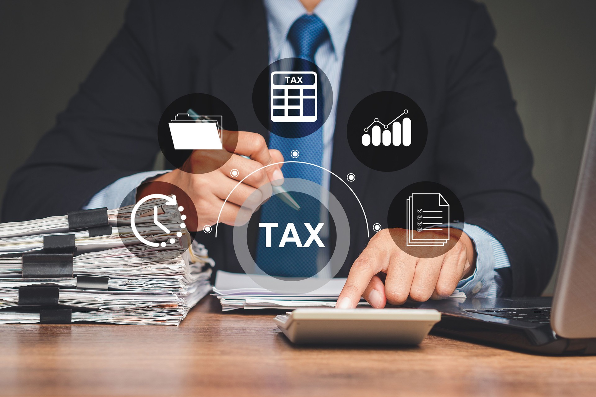 Businessman using a calculator to calculate taxes while sitting in the office